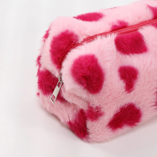 Pink and red heart-patterned pouch with a zipper on a white background